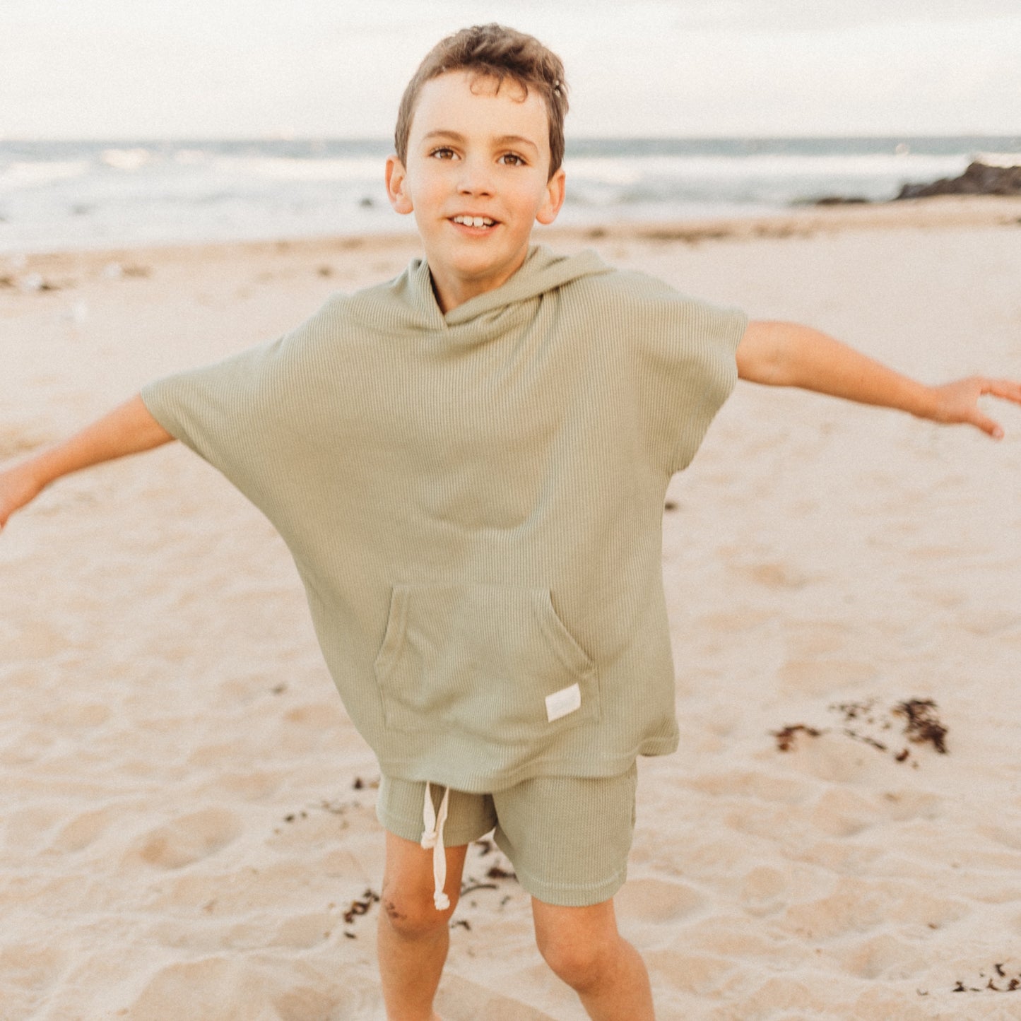 7 year old in Sage Green hooded towel and waffle shorts